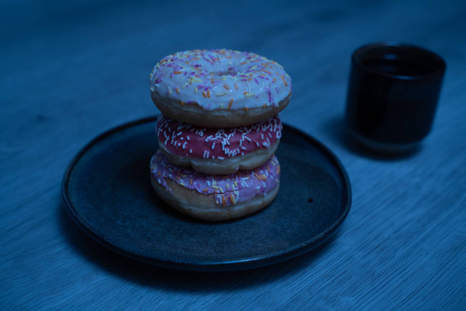 Stacked donuts lit only by the cool base