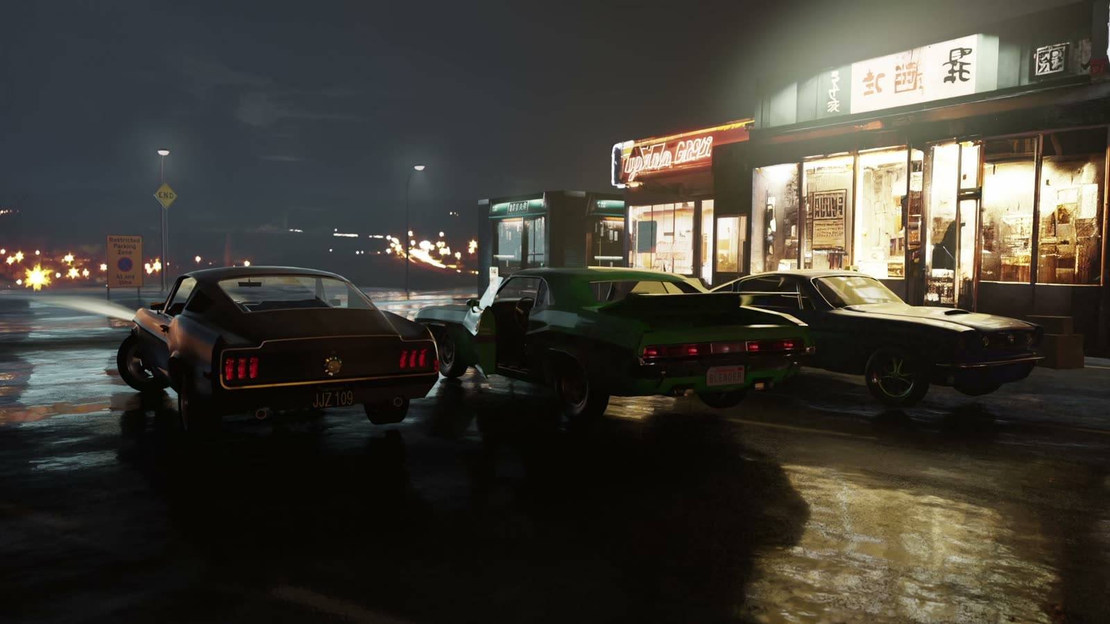Muscle cars outside lit shop fronts on a wet night street